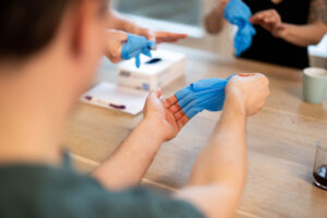 medewerker-doet-handschoenen-uit-tijdens-teamsessie (2)